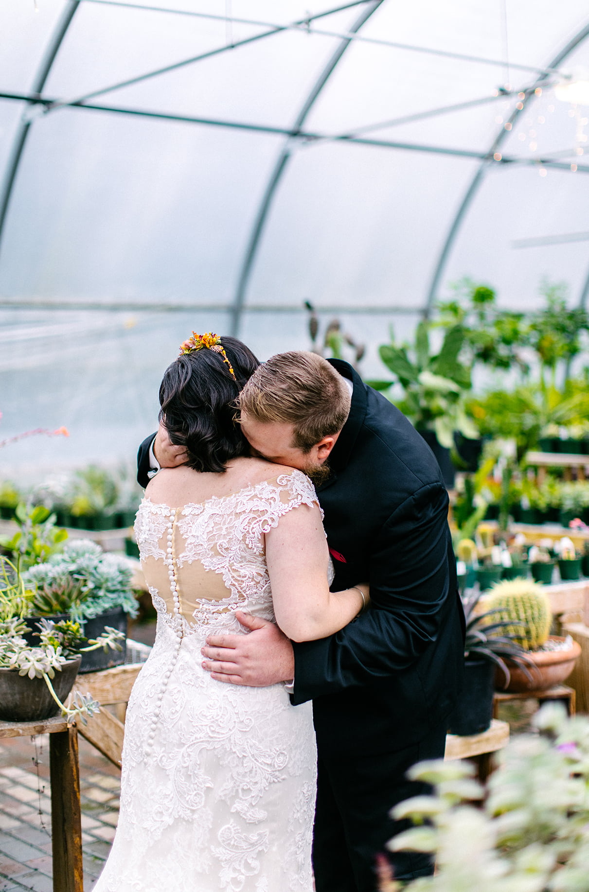 Bride and groom embrace at Carol Watson Greenhouse in Lafayette NY