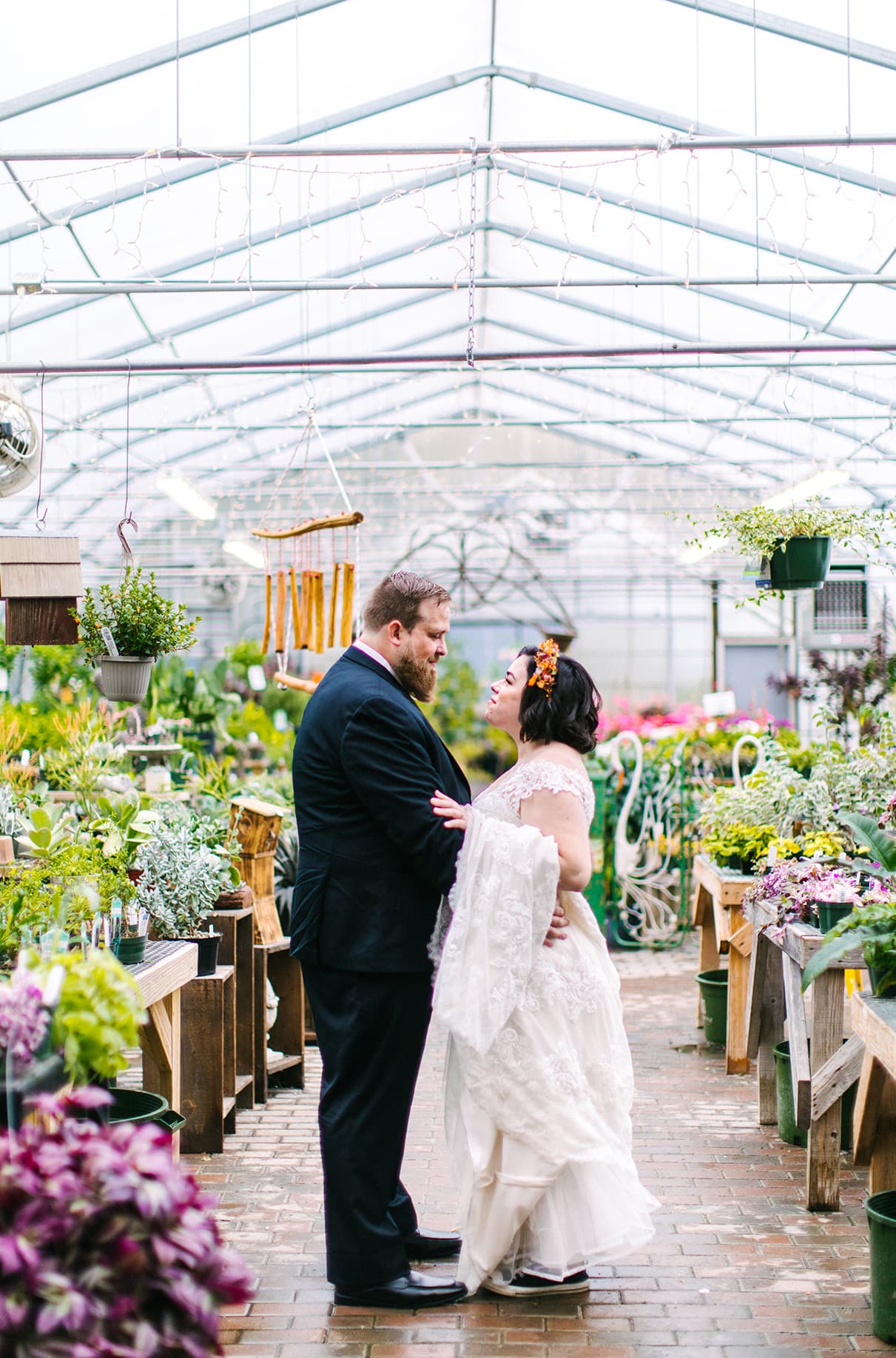 Bride and groom hold hands while looking at each other at Carol Watson Greenhouse in Lafayette NY