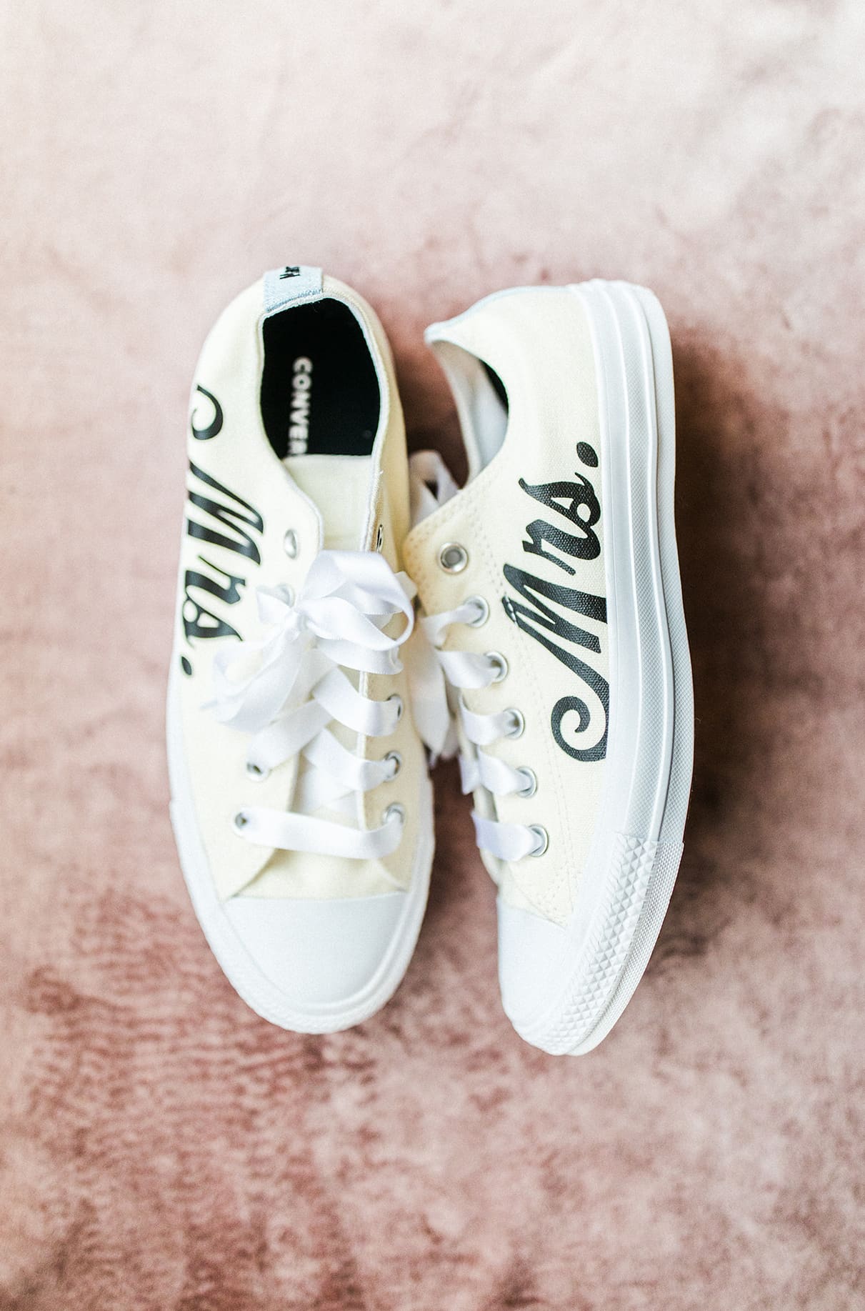 white converse sneakers with the word 