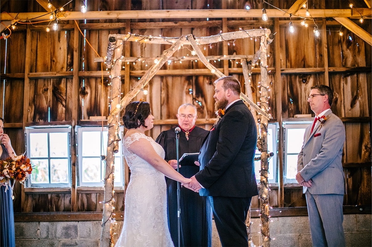 Bride and Groom stand together during wedding ceremony in the toolshed at Arlington Acres in Lafayette NY