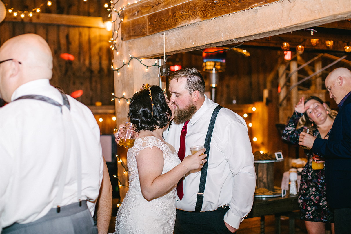 Bride and Groom kiss at the end of their wedding reception in a barn at Arlington Acres in Lafayette NY