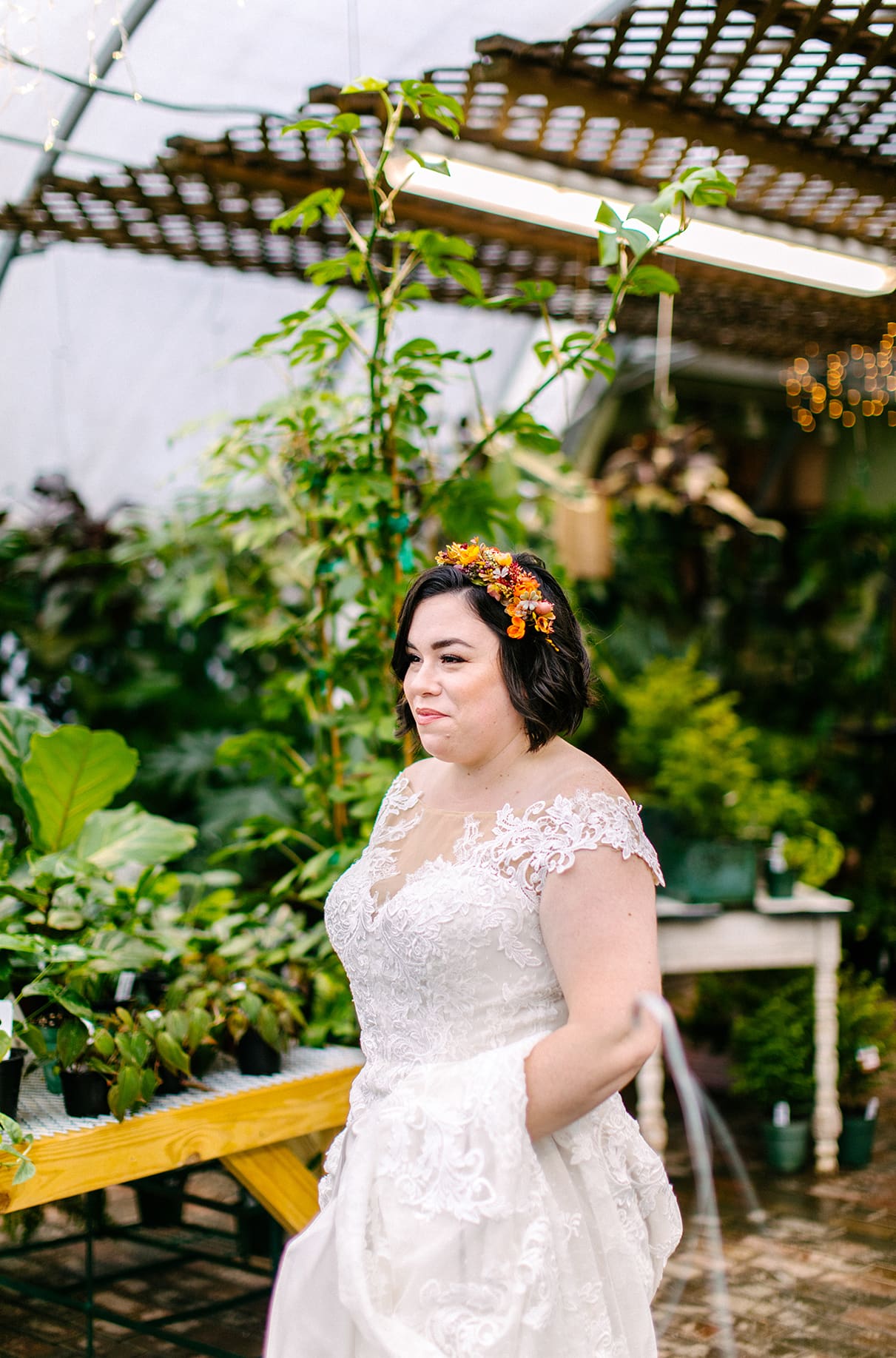 Bride stands smiling in Carol Watson Greenhouse in Lafayette NY