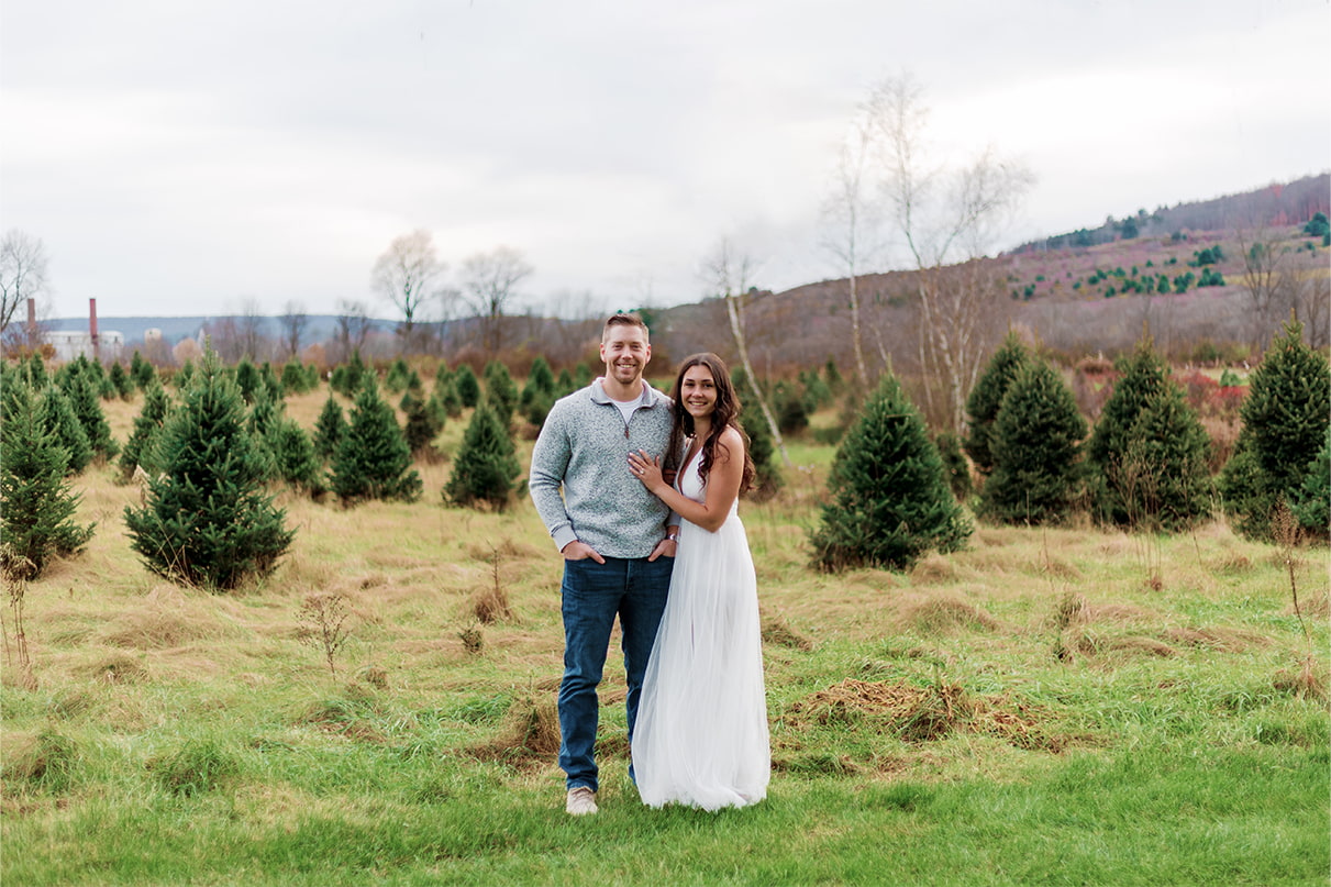 Couple standing together in Christmas Tree Farm field at Sipples Farm in Bainbridge NY