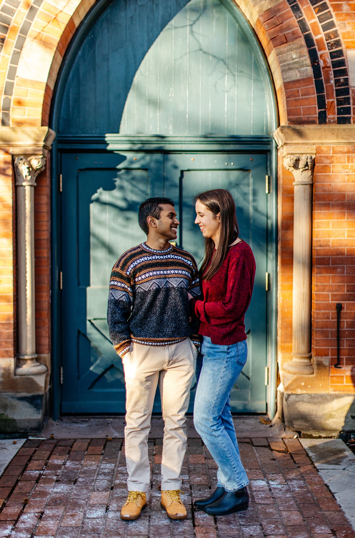 Couple holding hands and standing in front of Sage Chapel at Cornell University in Ithaca, NY