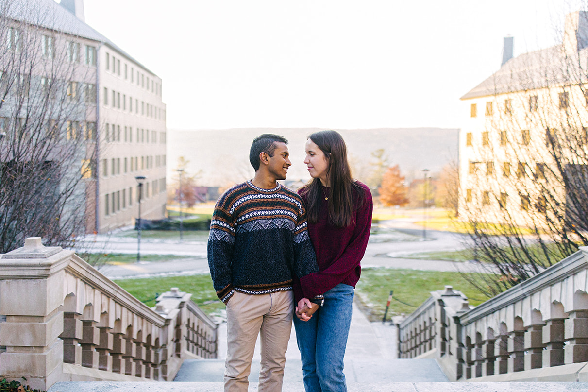 Couple holds hands and looks at each other on the Cornell University Campus in Ithaca, NY