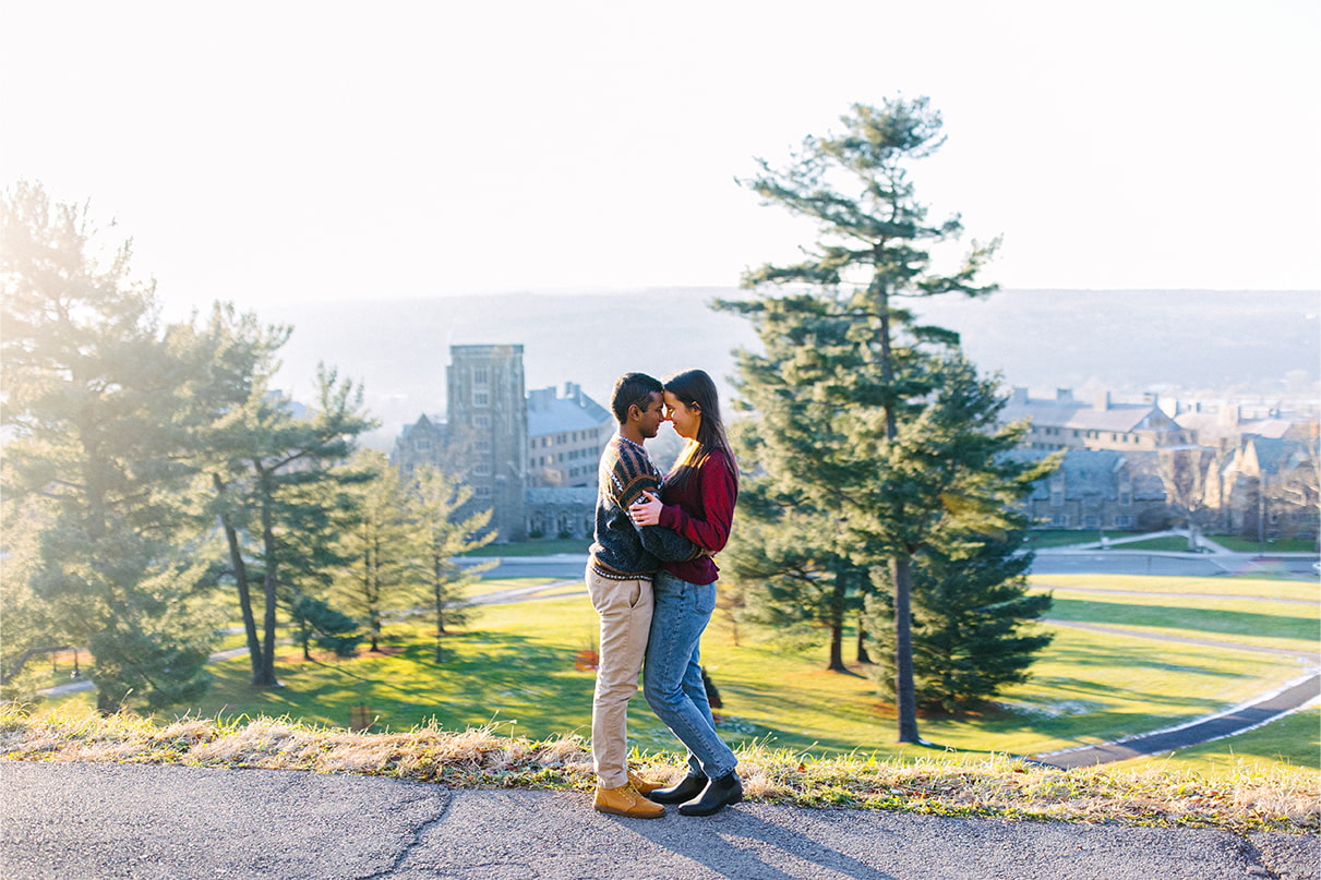 Couple embraces on hill overlooking Cornell University Campus in Ithaca, NY