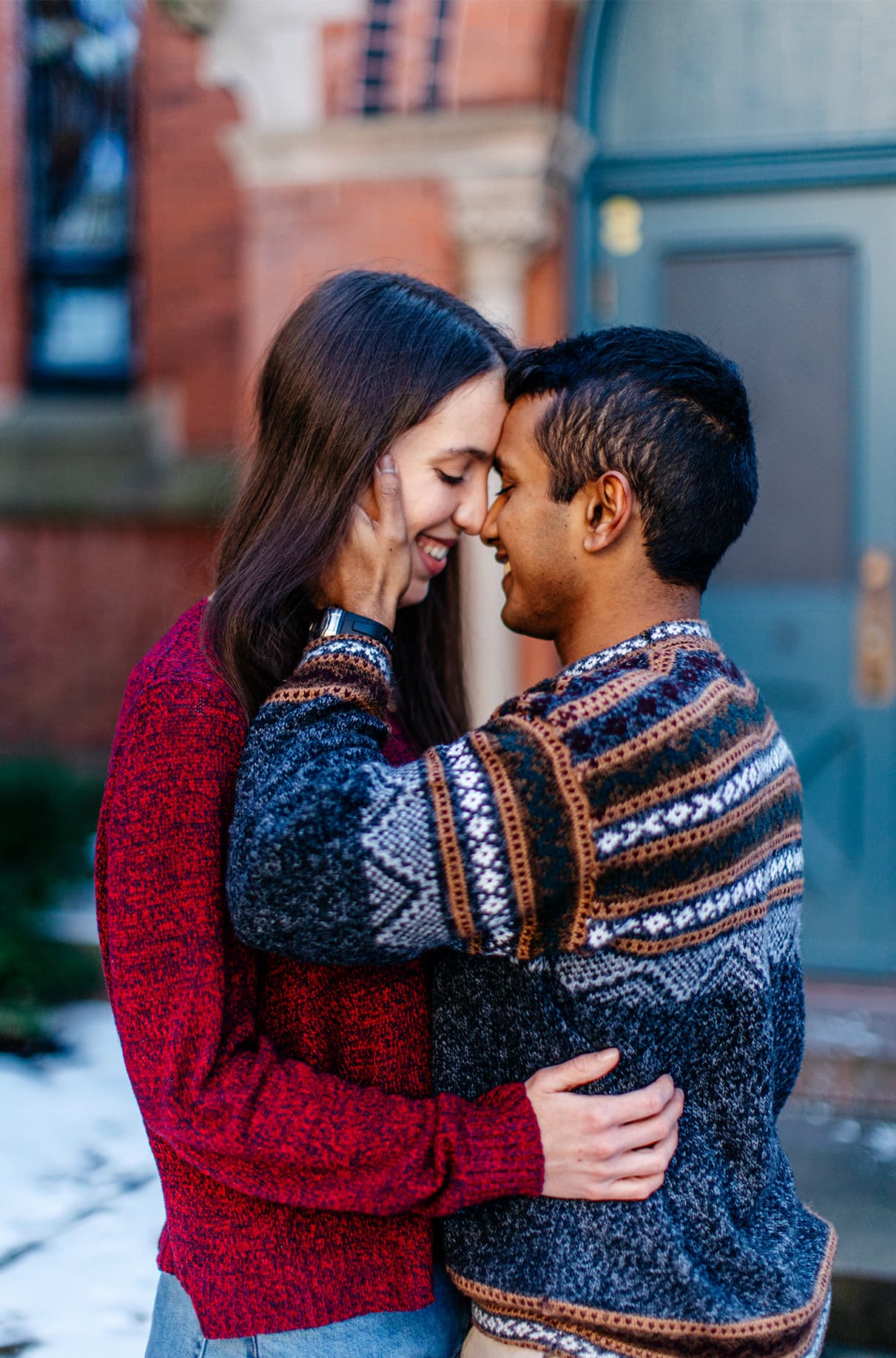 Couple embraces and smiles in front of Sage Chapel on the Cornell University Campus in Ithaca, NY