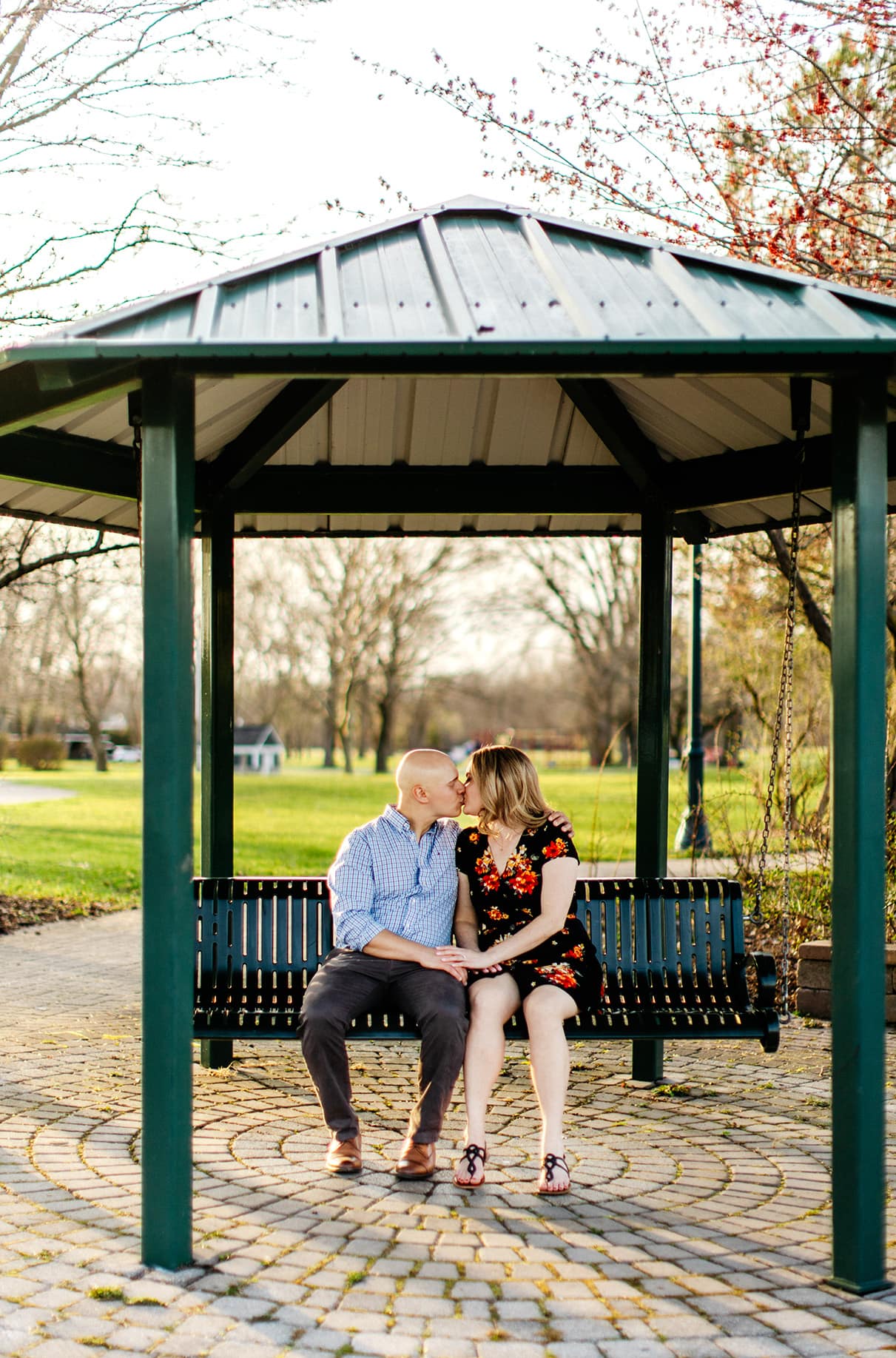 Couple sits on covered swing at Emerson Park in Auburn NY