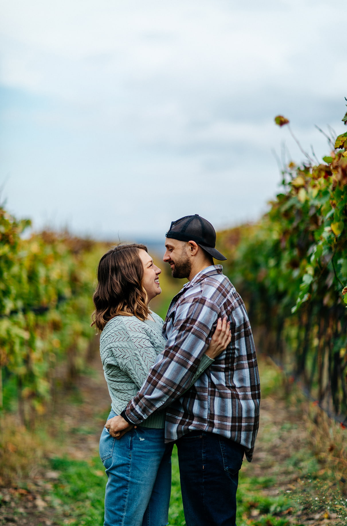 Couple embracing in Finger Lakes vineyard at Bet the Farm Winery in Trumansburg NY