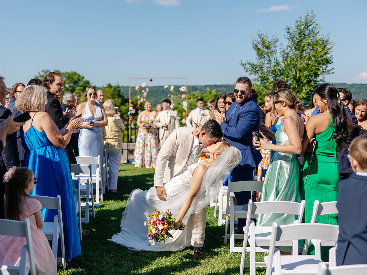 Groom dips bride for a kiss during the recessional at their wedding at the Inn at Taughannock Falls in Trumansburg, NY