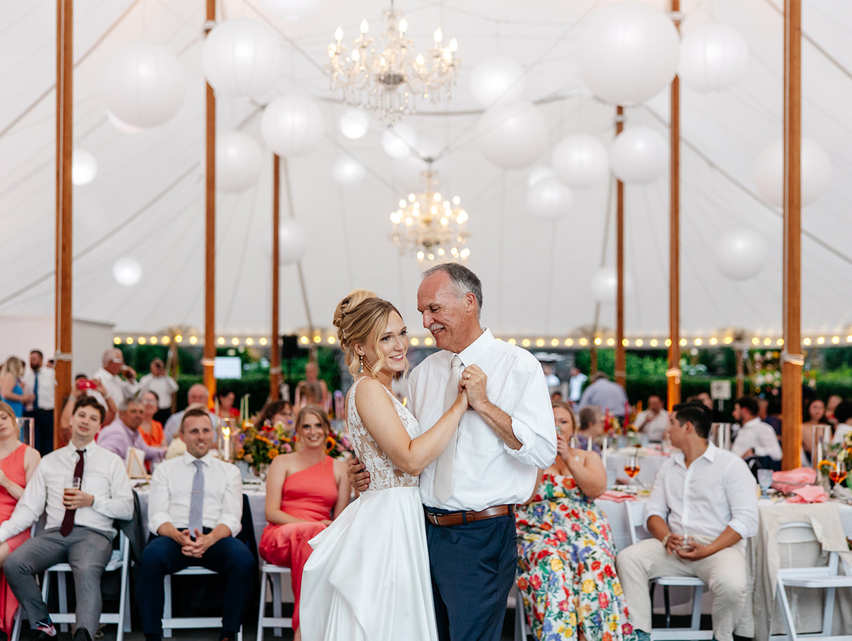 Bride dancing with her dad under a soaring sailcloth tent at her wedding at The Inn at Taughannock Falls in Trumansburg, NY