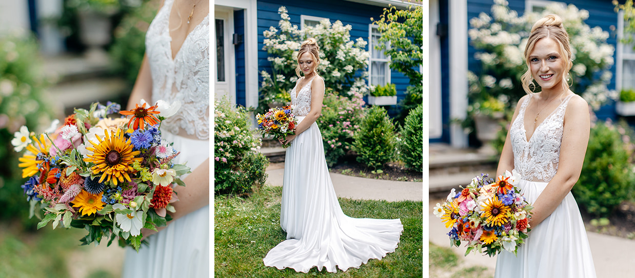 Bride stands in front of blue Hillside Lakehouse at The Inn at Taughannock. She holds a colorful bouquet of wildflowers