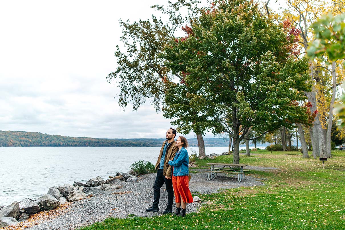 Couple stands in front of Cayuga lake at Taughannock Falls State Park