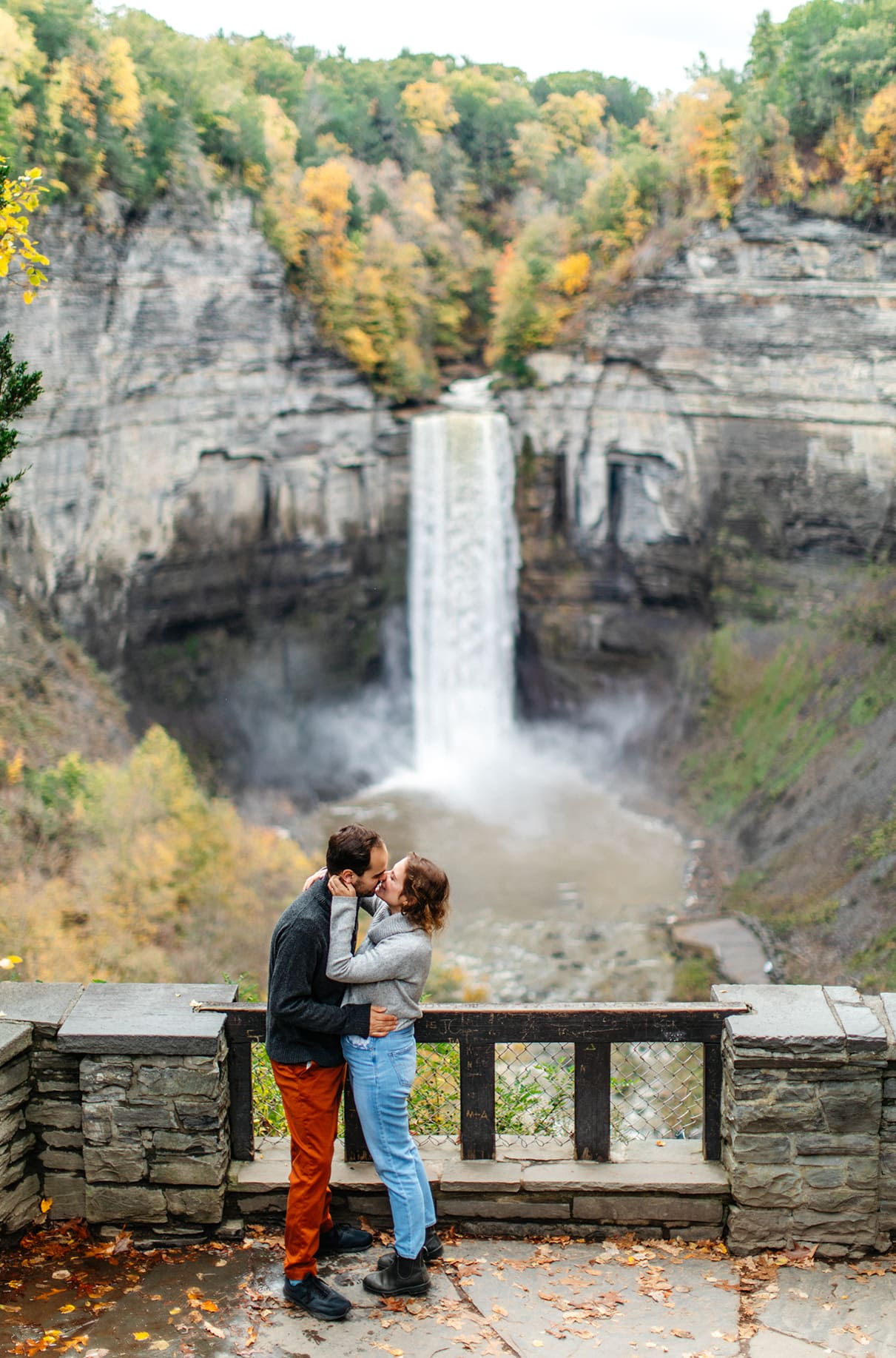 Couple kisses in front of falls at Taughannock Falls State Park