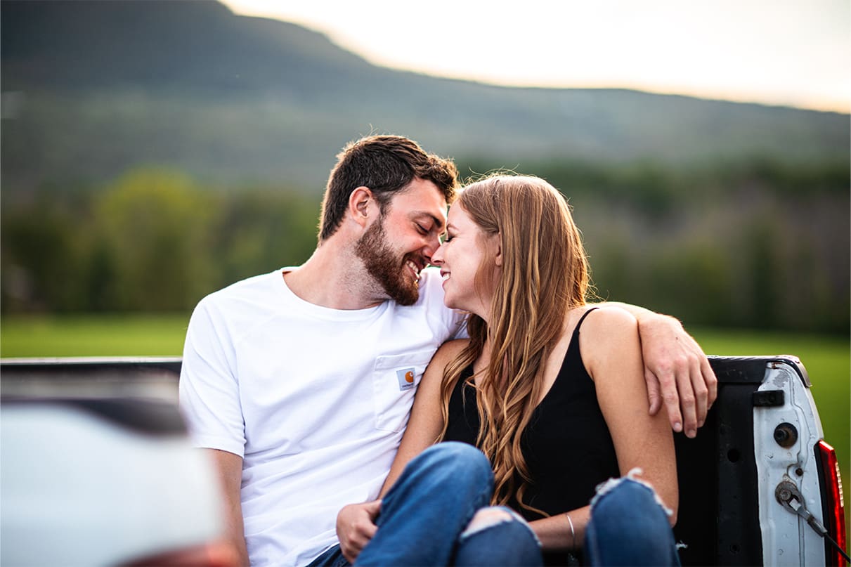 Couple sits in Ford truck bed and kisses during engagement session in Albany NY