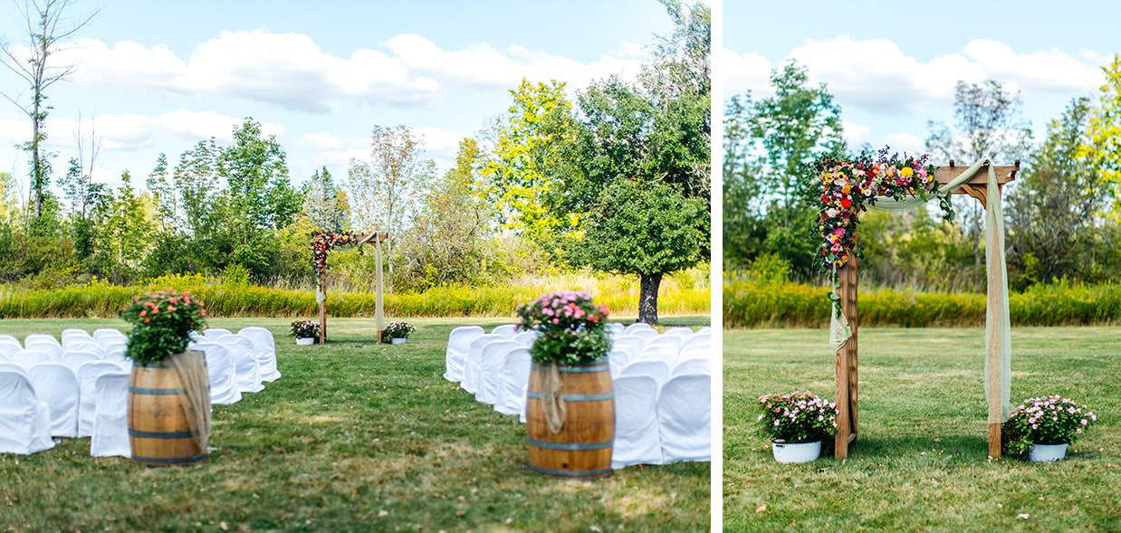 wedding ceremony space with whiskey barrels and an arch covered in colorful wooden flowers in a field at Apple Blossom Acres in Freeville NY