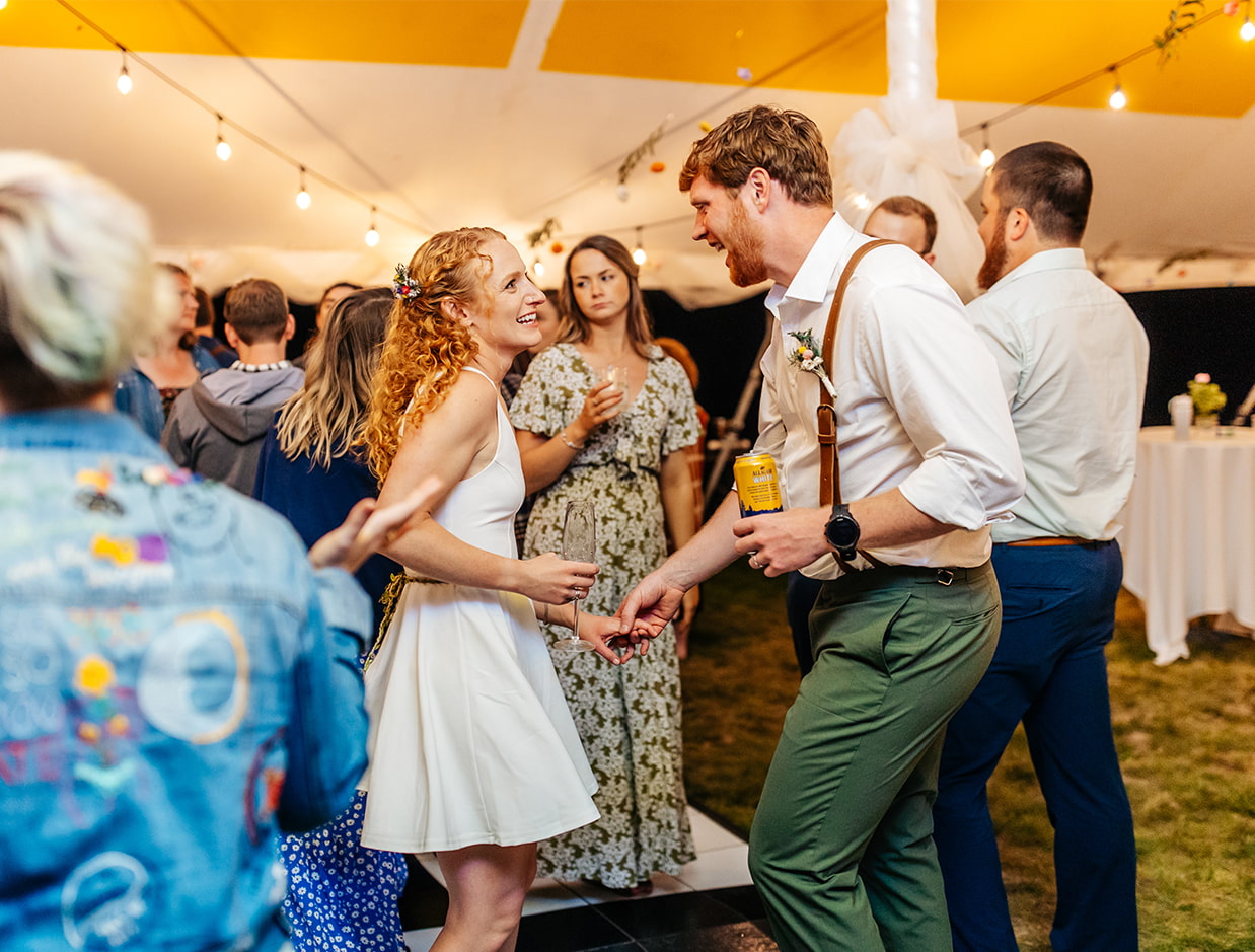 bride and groom dance together during tented wedding reception at Apple Blossom Acres in Freeville NY