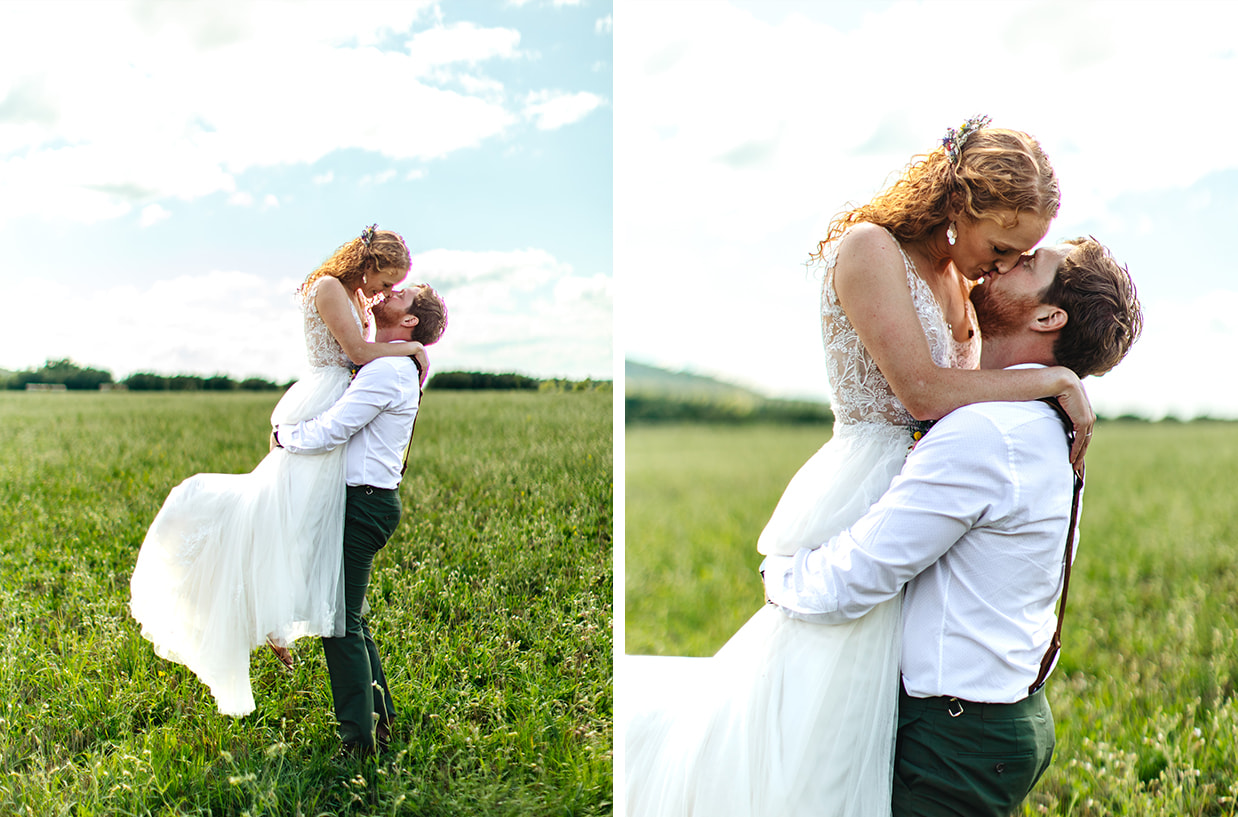 groom lifts bride and they kiss while standing in a field at Apple Blossom Acres in Freeville NY