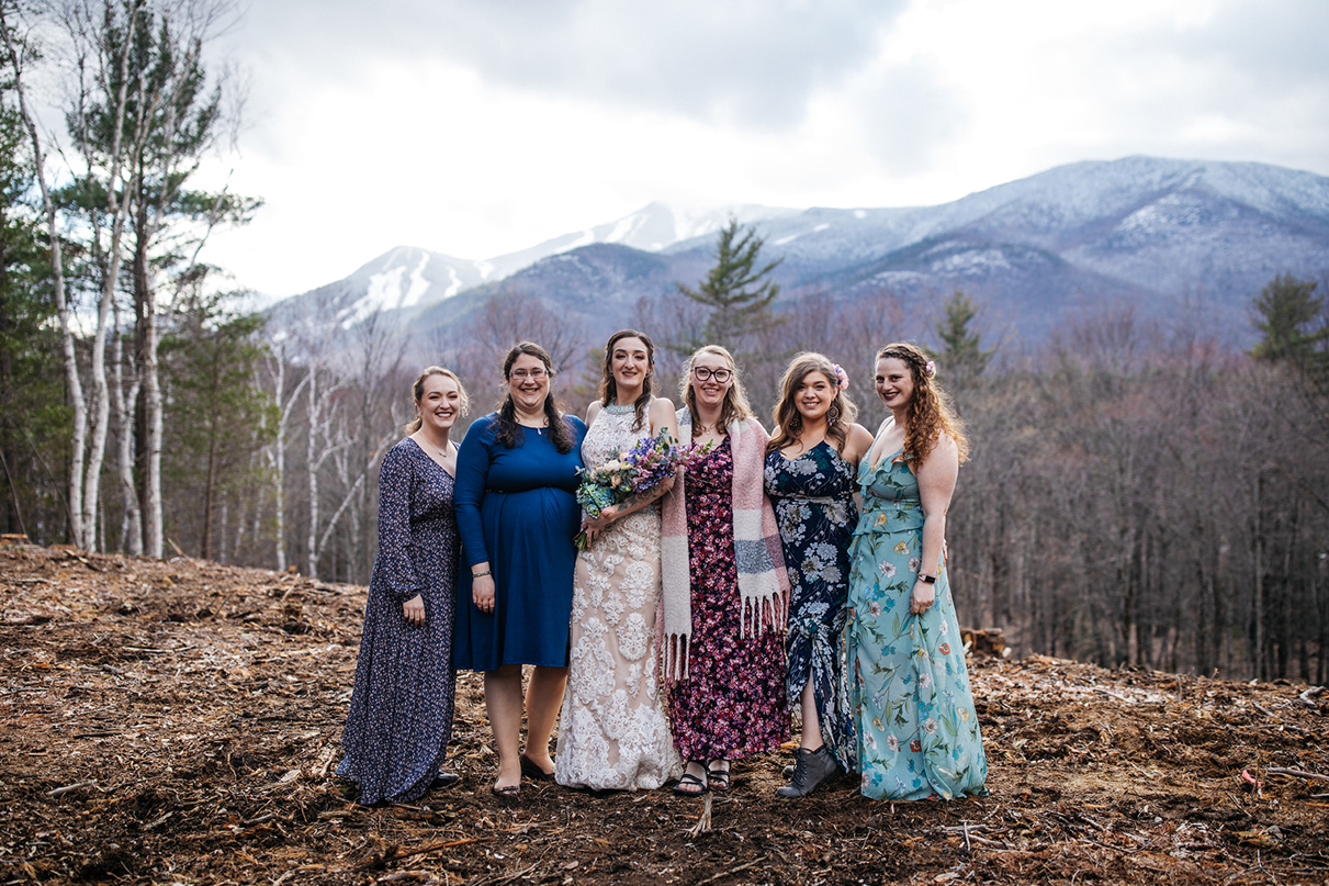Bride stands with bridesmaids in front of whiteface mountain Wilmington NY