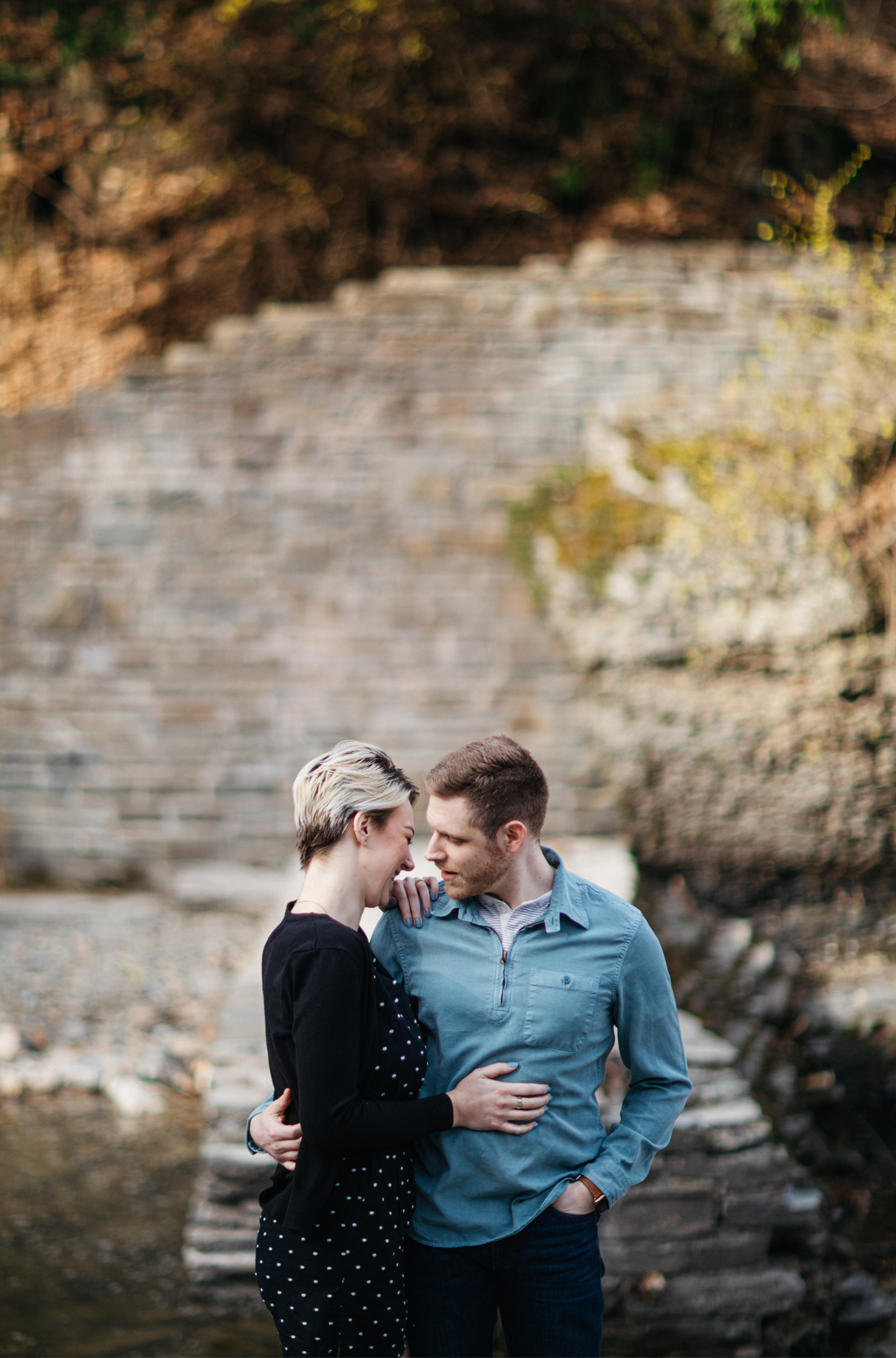 Couple embraces and smiles during Buttermilk falls engagement session Ithaca NY