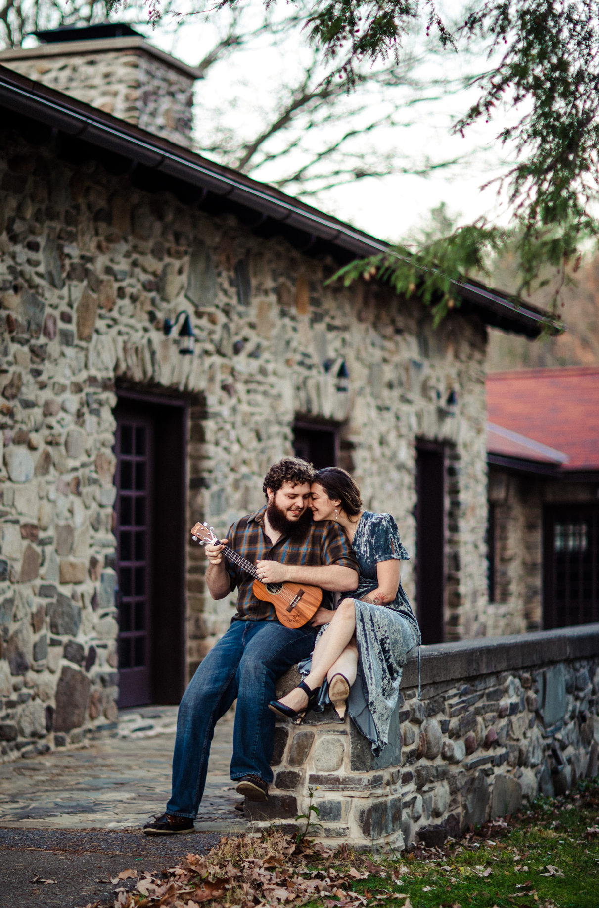 couple sits and plays ukulele during engagement session