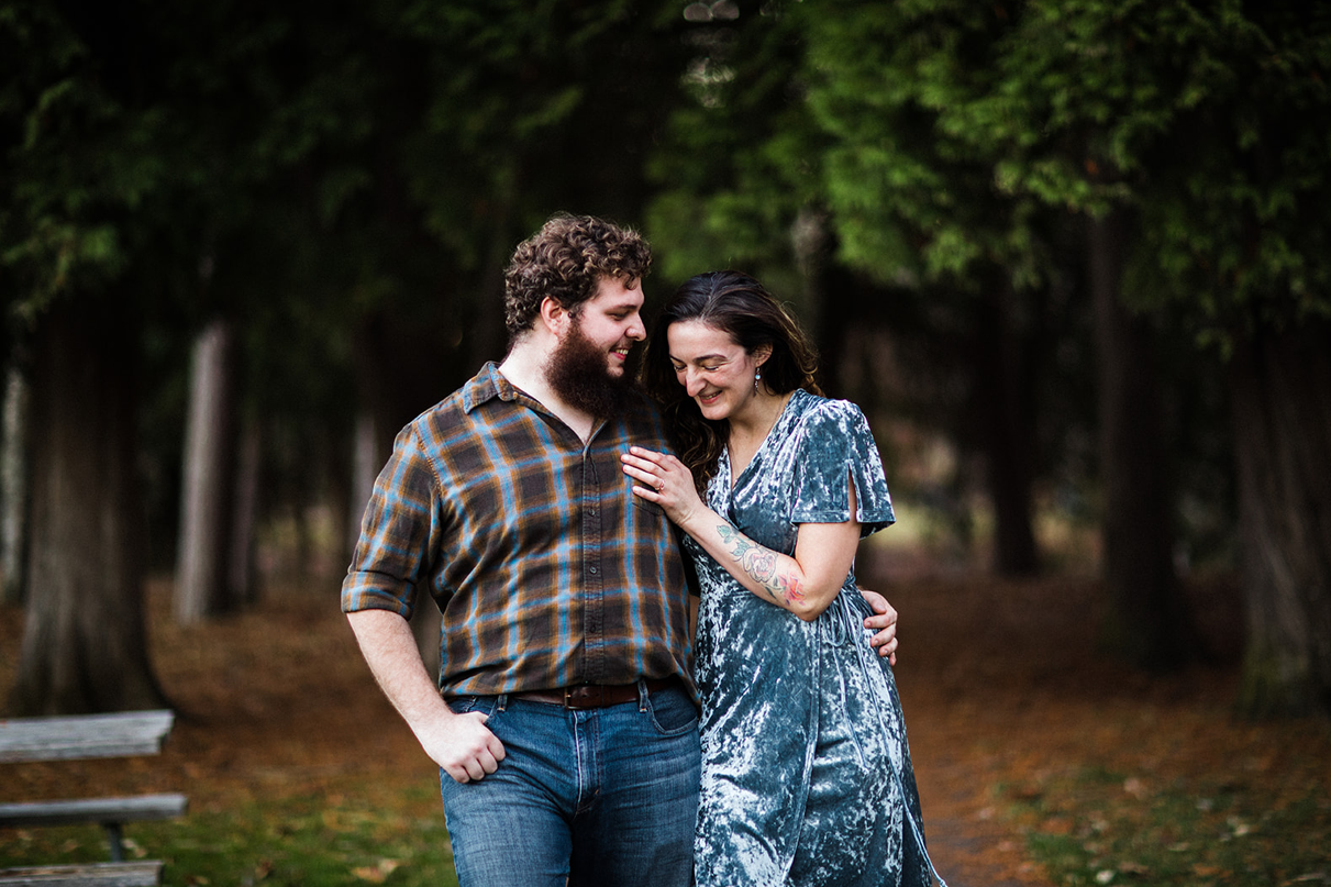 Couple walks through woods holding hands during Chenango Valley State Park engagement session