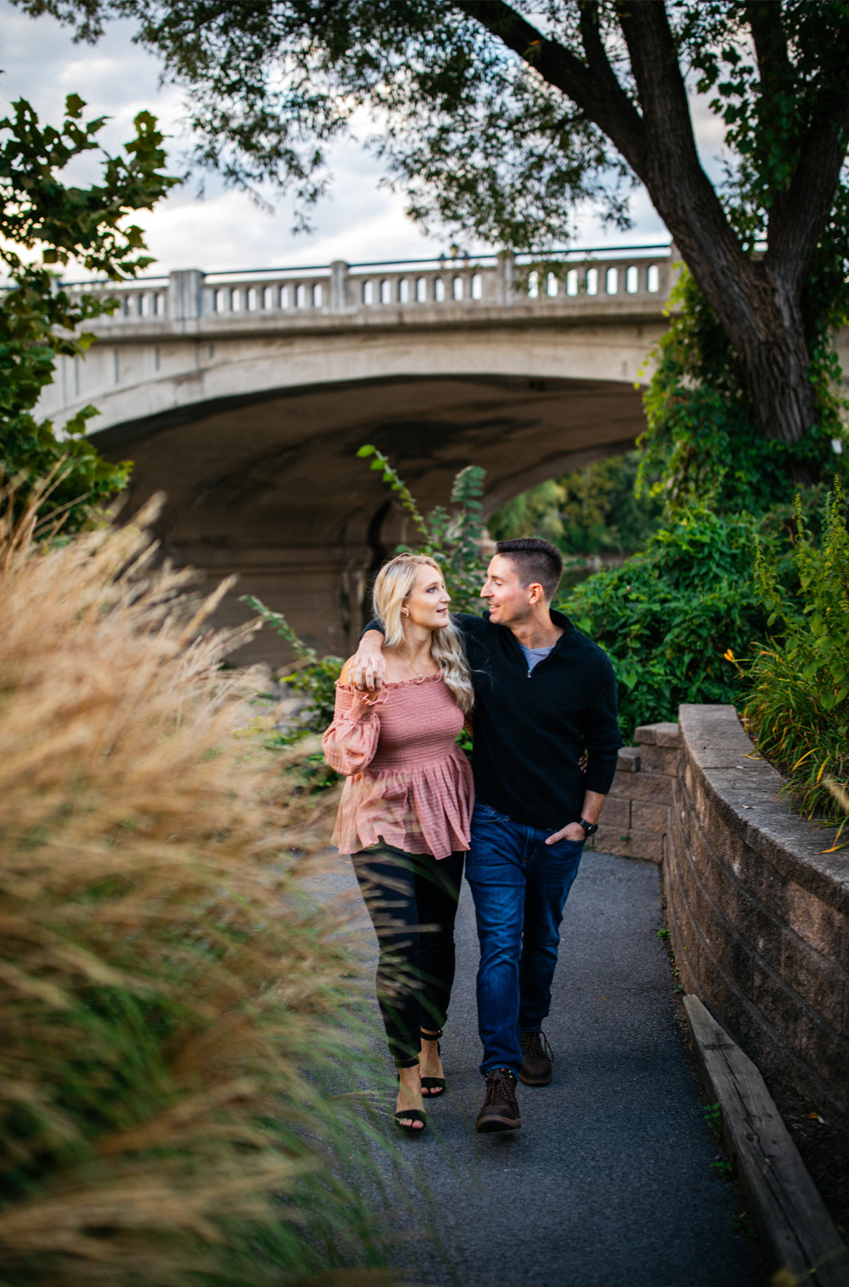 Couple holds hands while smiling at each other in Confluence Park couples photos