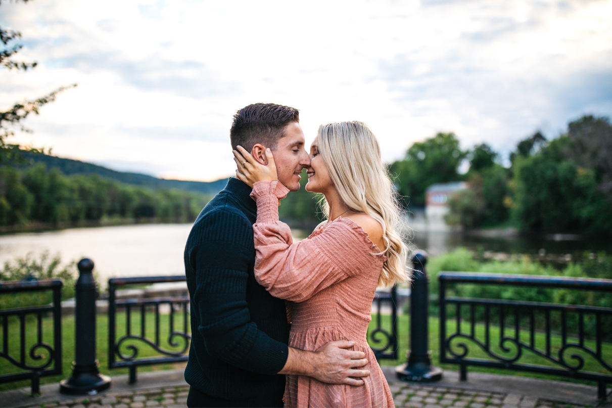 Couple almost kisses in front of Susquehanna river Binghamton engagement photos