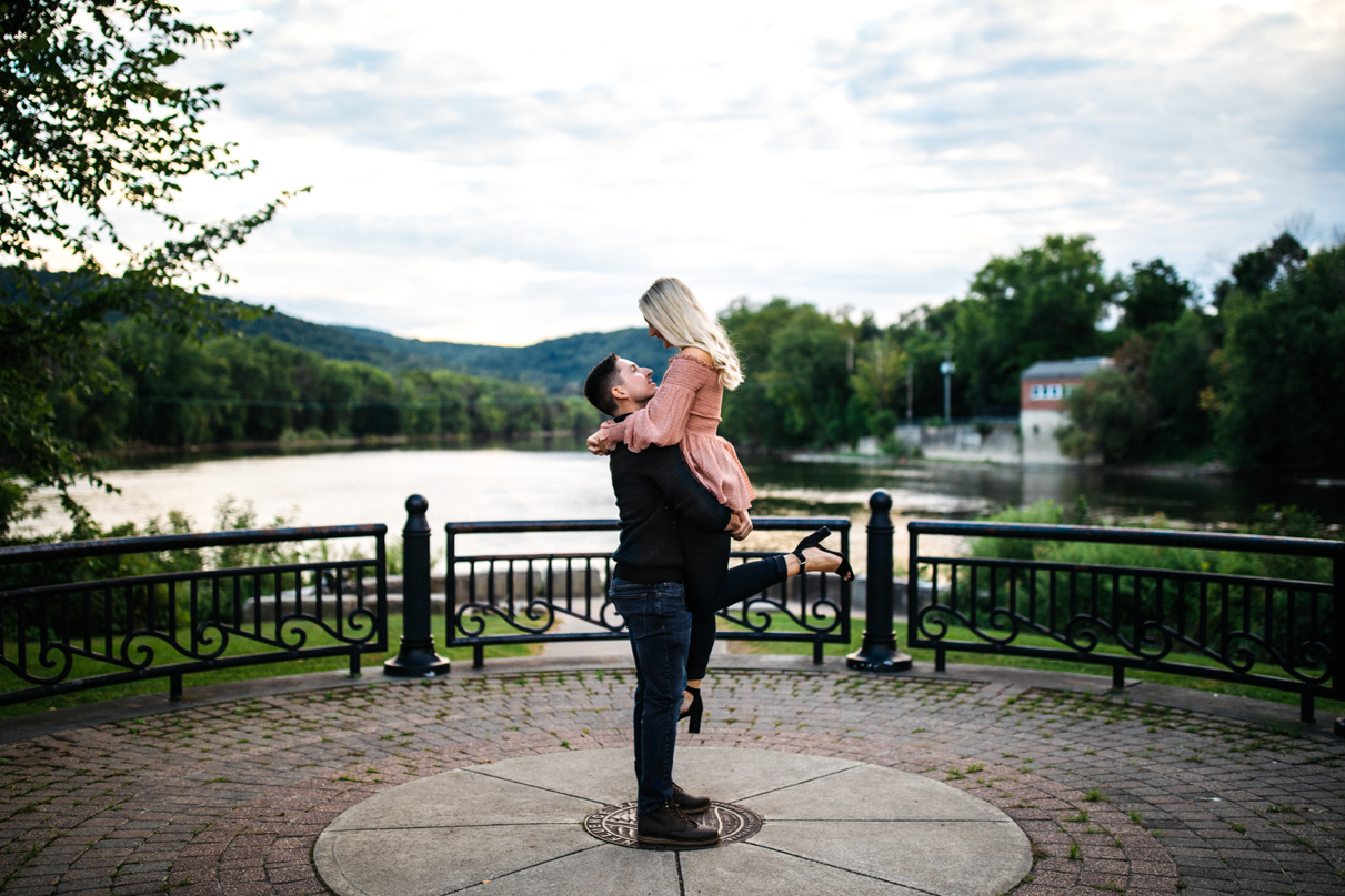 Man picks up woman in romantic lift binghamton engagement photos river