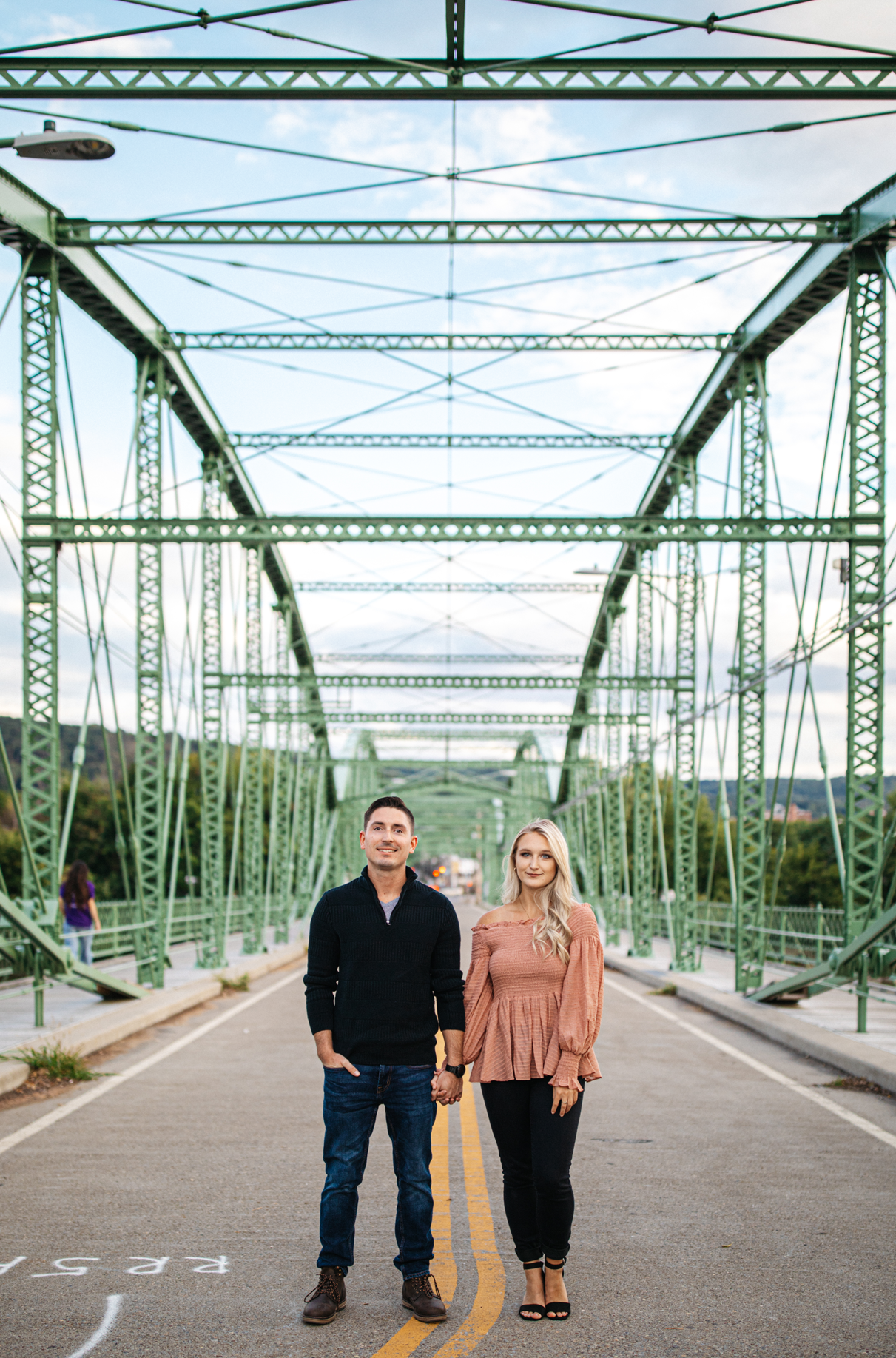 couple holds hands on Confluence Park bridge in Binghamton NY