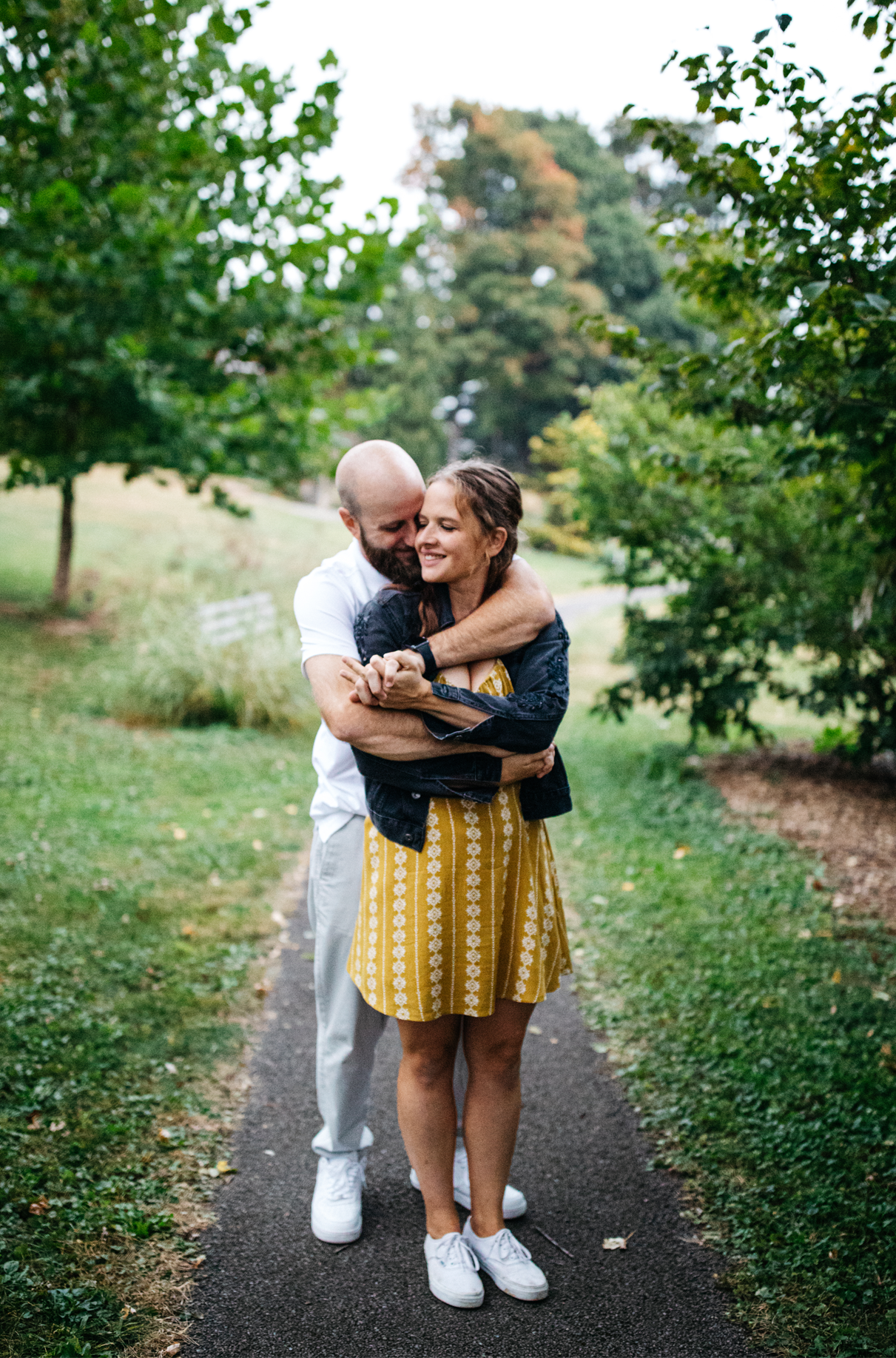 couple embraces on garden path in binghamton ny engagement session