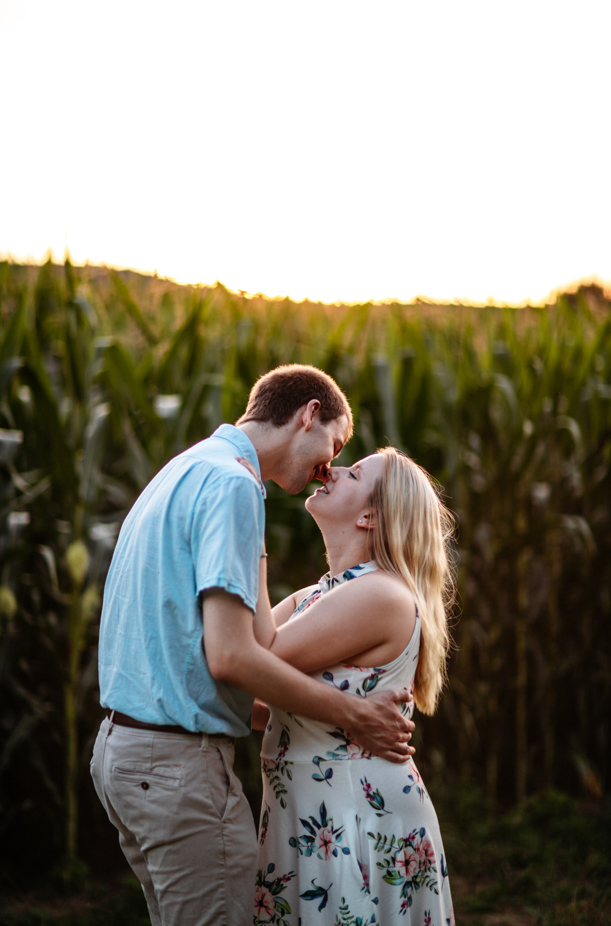 couple almost kisses in front of cornfield park engagement session