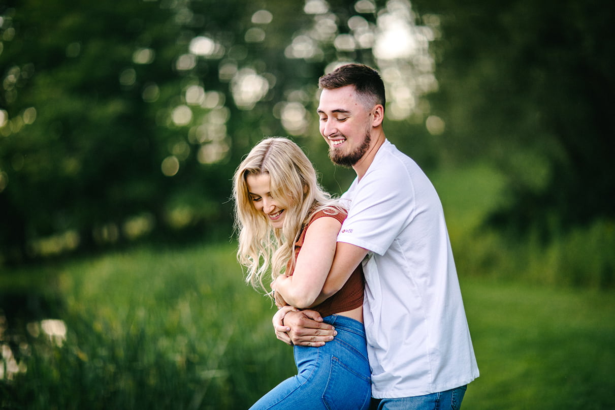 Man grabs woman from behind and spins her as they laugh