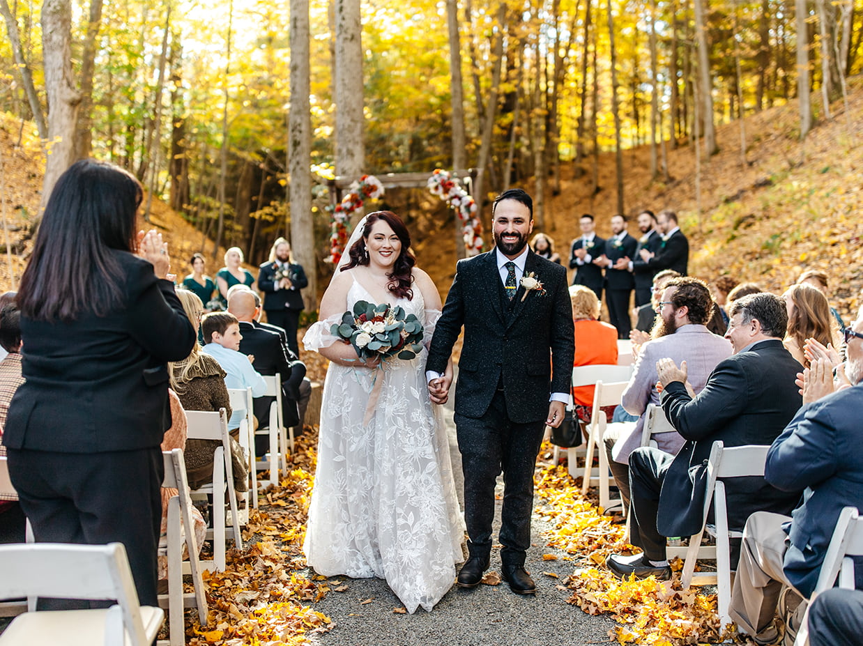 bride and groom walk down the aisle during a fall wedding in the finger lakes