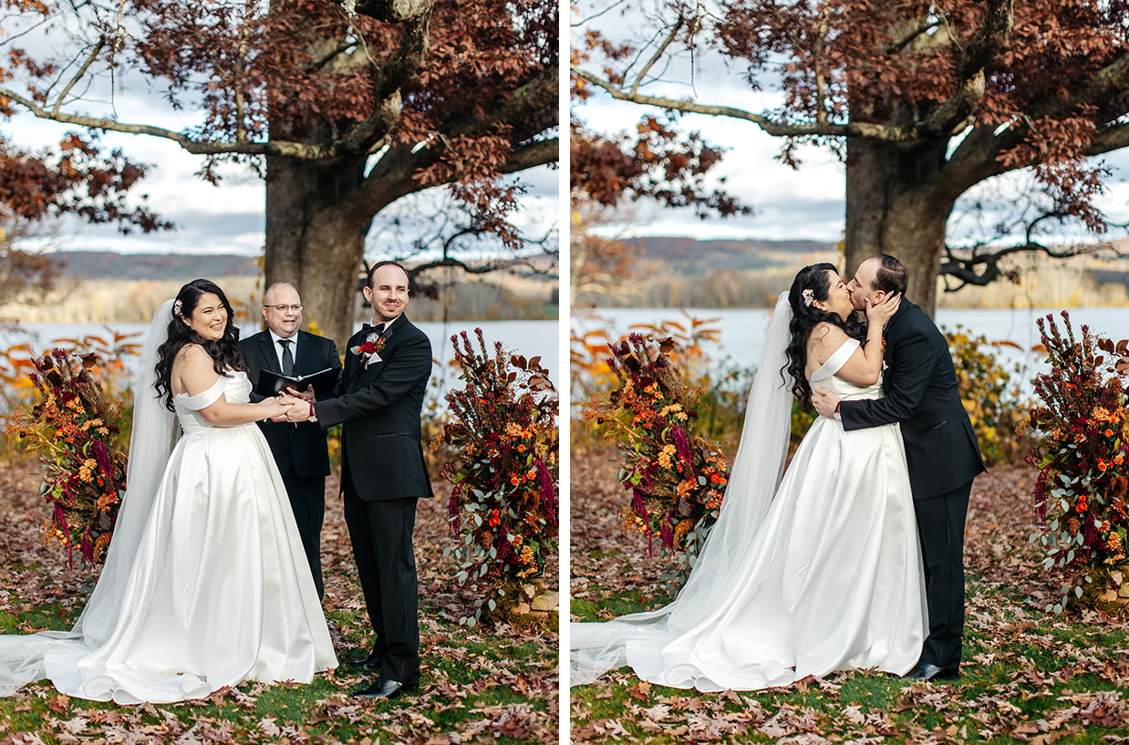bride and groom share their first kiss with colorful fall foliage and Cayuta lake as the background during their wedding at Fontainebleau Inn in Alpine NY