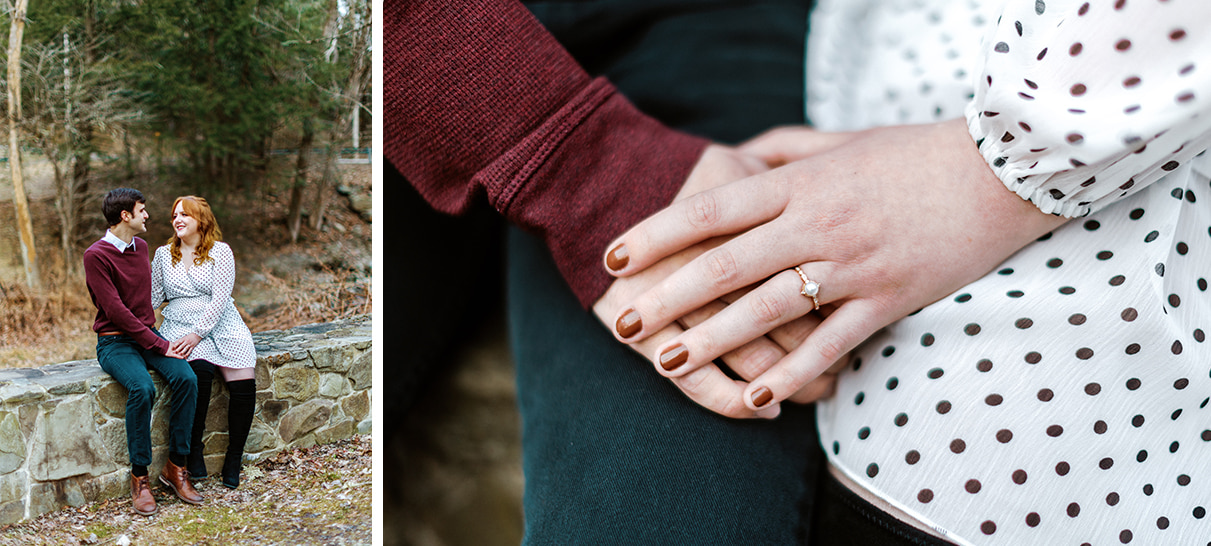 Couple sits on stone wall smiling at each other. Woman is wearing a pearl engagement ring