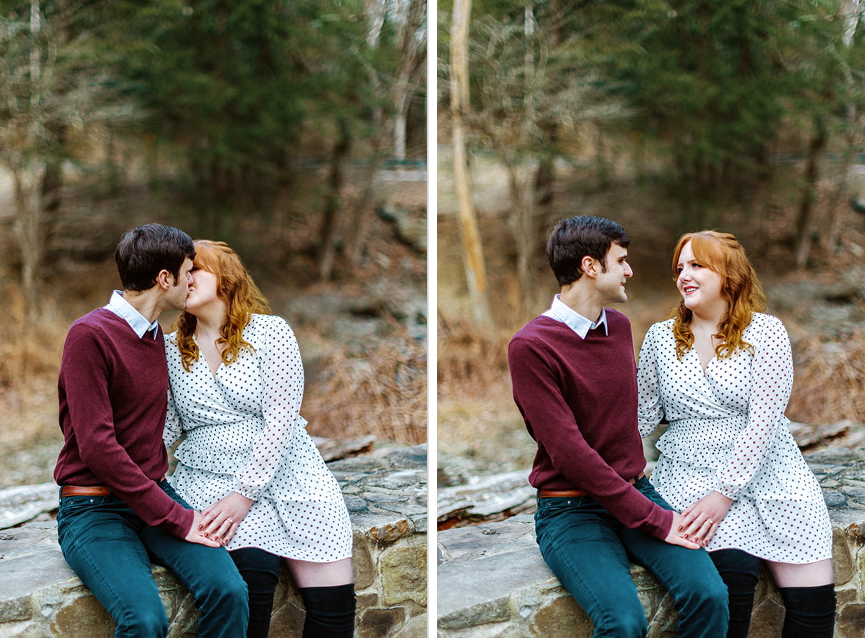Couple sits on stone wall while looking at each other and kisses