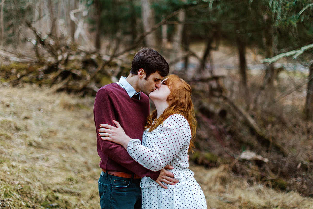Couple kisses in the forest during their engagement session at Glen Park Vineyards in Owego NY