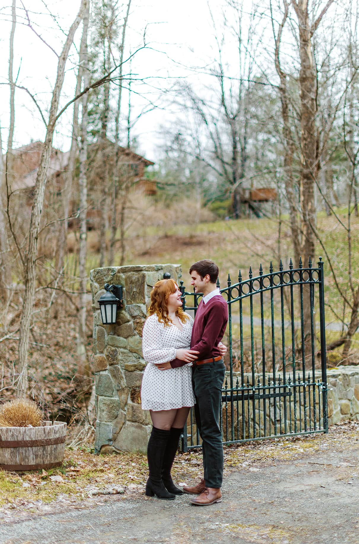 Couple embraces standing in front of iron fence during upstate ny engagement photos