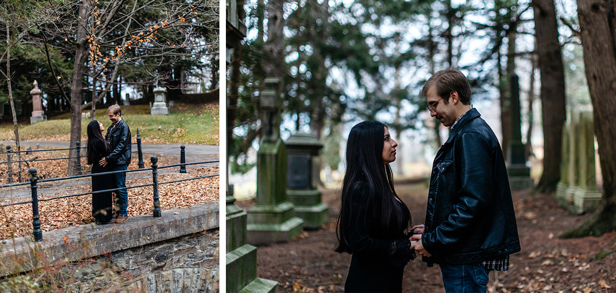 couple in dark clothes hold hands in a cemetery during engagement session