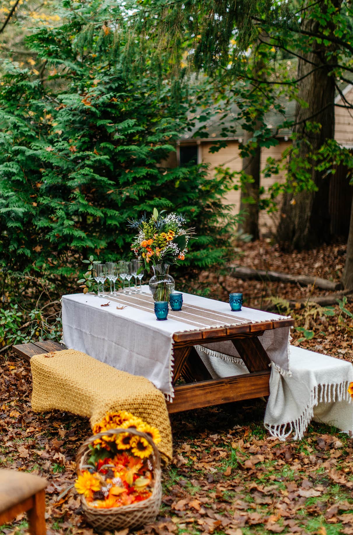 picnic table with fall bouquet and cozy blankets