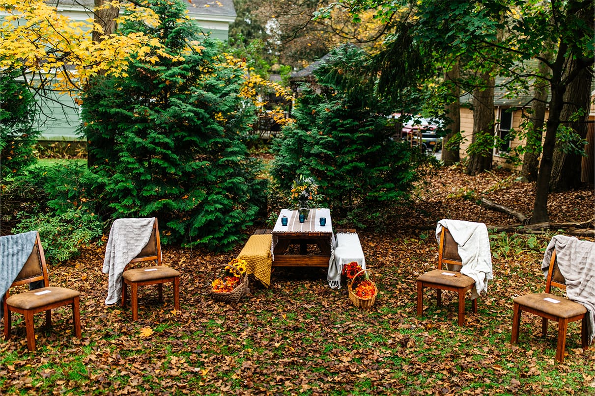 picnic table and four chairs with faux fur blankets draped over them