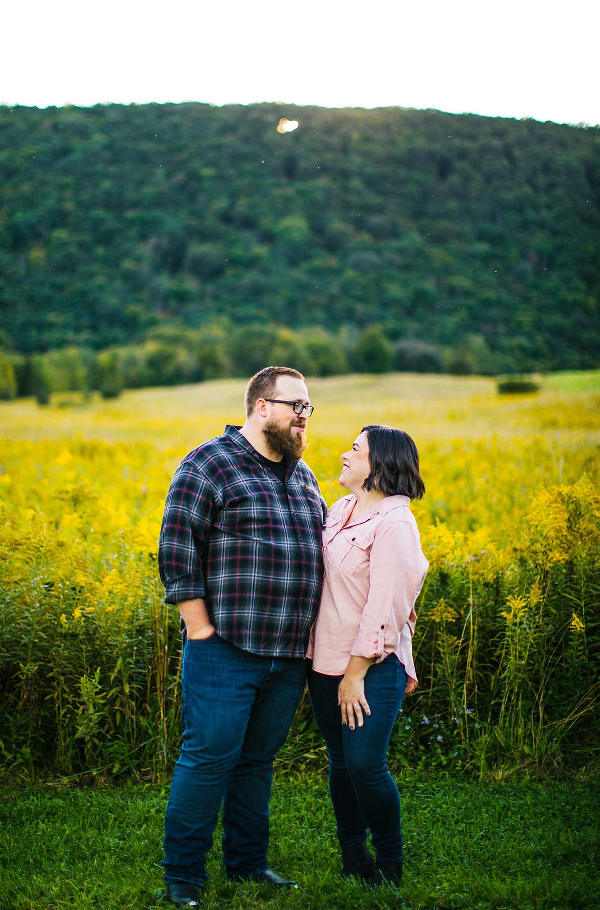 couple embraces and laughs during engagement session at labrador pond