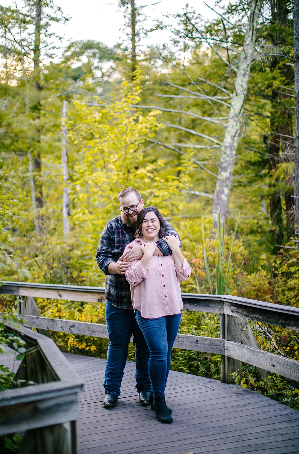 couple embraces and laughs during engagement session at labrador pond in tully ny