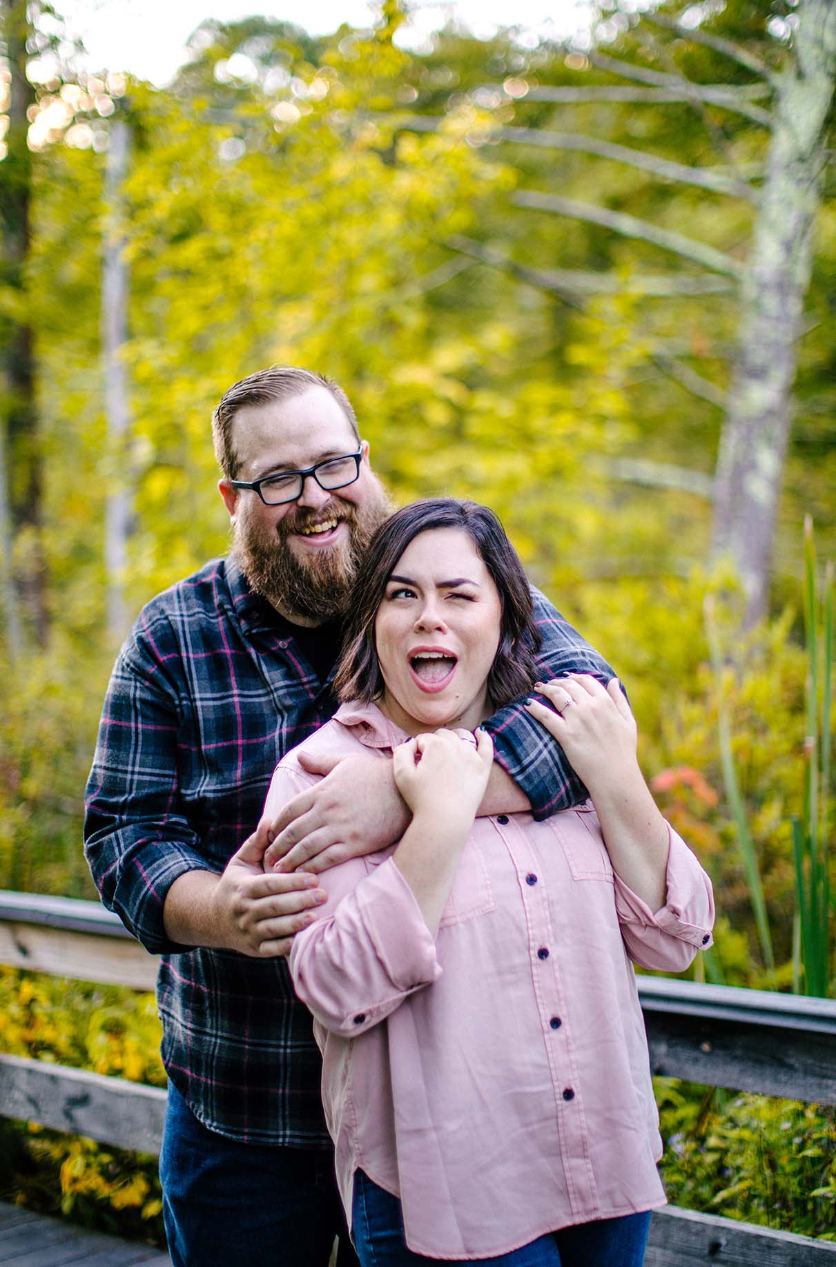 couple laughs and makes silly faces during engagement session at labrador pond in tully ny