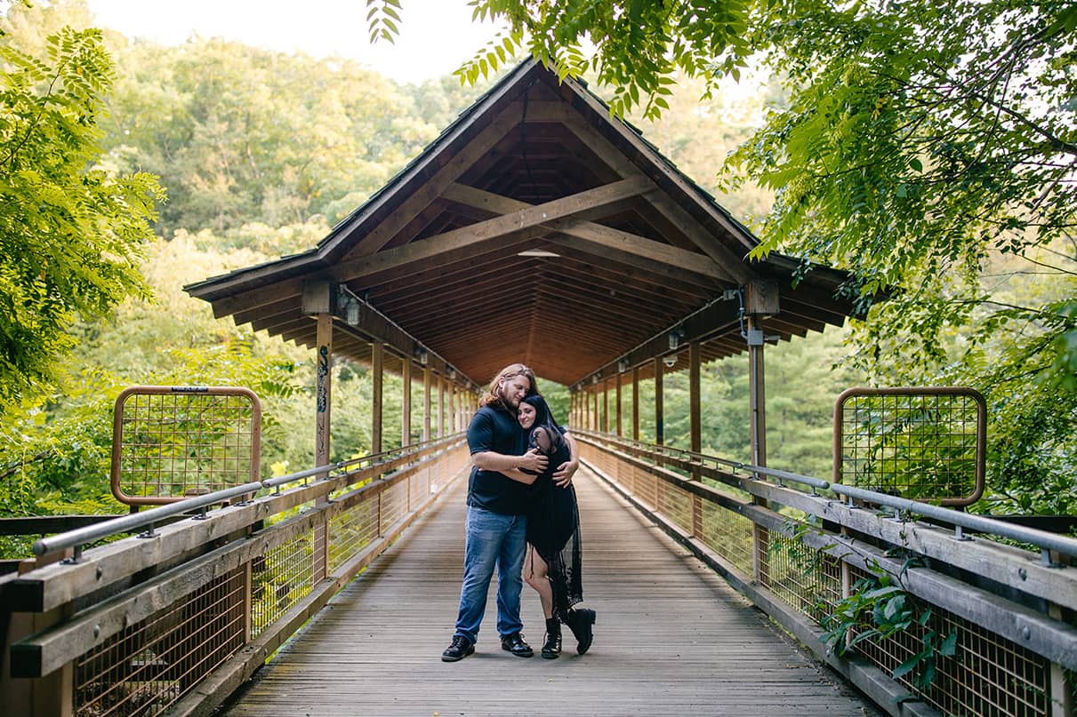 Couple embraces on Nay Aug Park Bridge Engagement photos