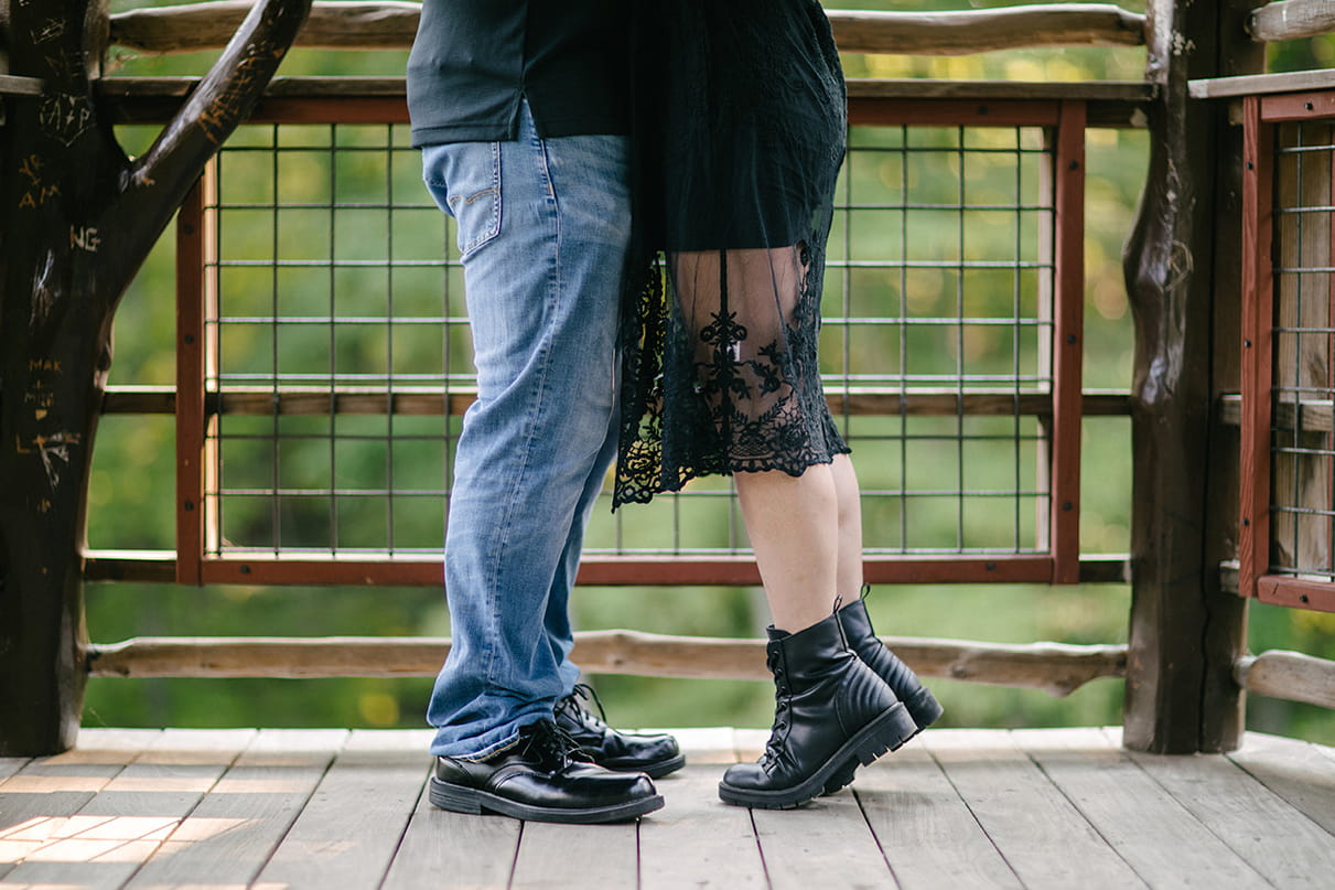 Couples feet as woman stands on toes in treehouse