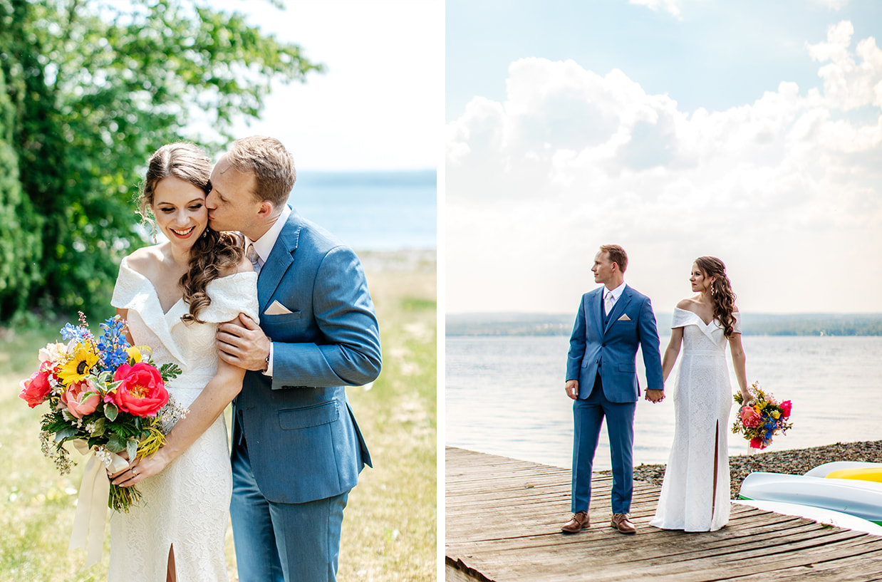 Groom and bride holding colorful pink and yellow bouquet stand on dock overlooking seneca lake