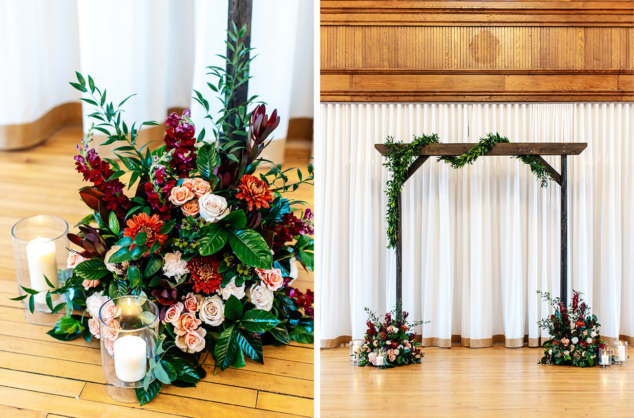 ceremony arch decorated with greenery, red, pink, and orange flowers, and candles at The Historic German House in Rochester NY