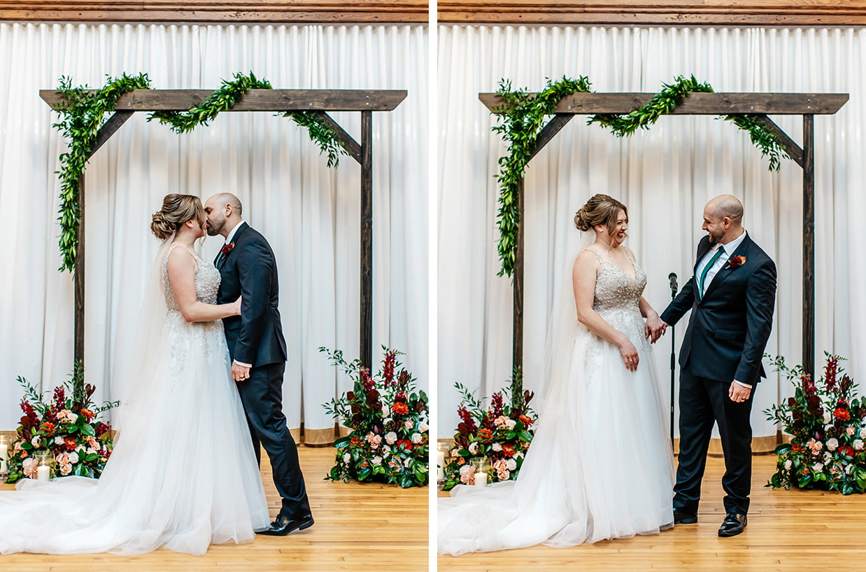 Bride and groom share their first kiss and laugh in front of floral ceremony arch at The Historic German House in Rochester NY